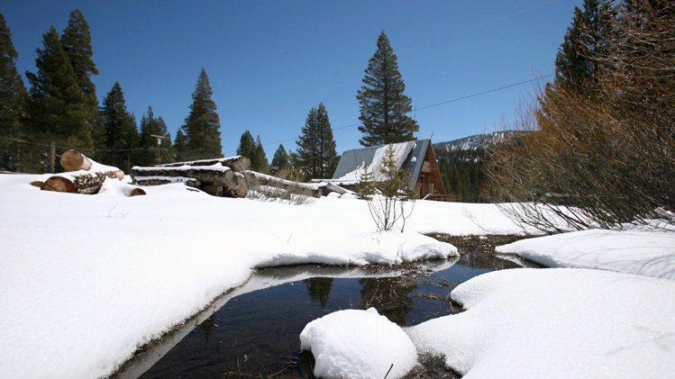 FILE-This April 30,2010 file photo shows a stream seen running through snow covered banks near the site of the Department of Water Resources snow survey at Echo Summit, Calif. A new report released Thursday Aug. 7,2013 found climate change is affecting California. Over the past century, snowpack runoff has decreased due to warmer winters and earlier arrival of spring. (AP Photo/Rich Pedroncelli,File)